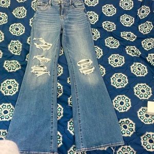 I am selling these flared wide at the bottom American Eagle ripped jeans.